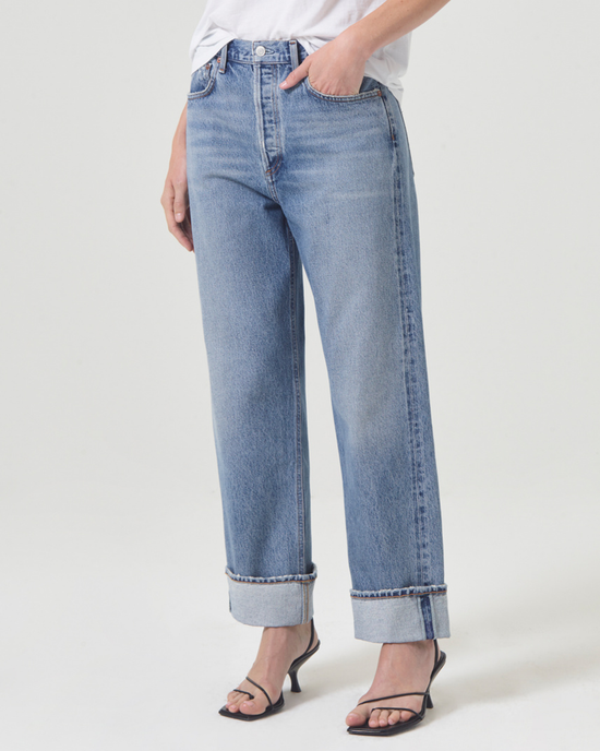 Woman wearing AGOLDE Fran Low Slung Straight in Invention Jean in a relaxed fit, made from non-stretch organic cotton, and black strap sandals.