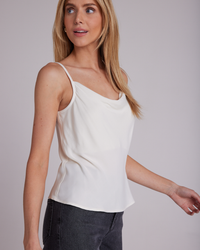 Woman wearing a Bella Dahl Cowl Neck Camisole in Winter White and gray pants.