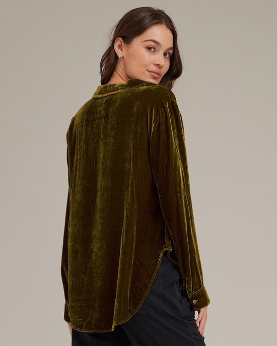 Woman wearing a Bella Dahl Long Sleeve Clean Shirt in Olive Gold looking over her shoulder.