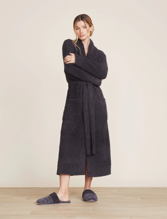 A woman stands in a neutral pose wearing a Barefoot Dreams Cozychic Solid Robe in Carbon and matching slippers.