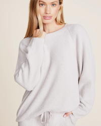 Woman in a soft, pale Barefoot Dreams CCL Rib Blocked Pullover in Silver with dolman sleeves, posing against a neutral background.