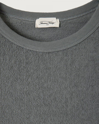 Close-up of a gray Boby Park L/S Crew garment with an American Vintage brand label at the neckline.
