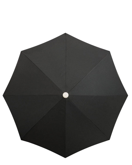 The Amalfi Umbrella - Rivie Black by Business & Pleasure Co is shown from above, featuring an eight-panel, UV and water-resistant canopy with a unique circular center hub.