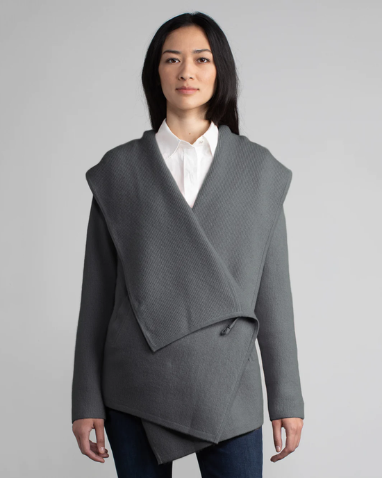 Woman in a gray asymmetrical top, and white shirt under a Margaret O'Leary St. Claire in Steel cashmere coat.