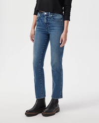 Person wearing AMO's Chloe Crop in True Love blue jeans and black boots against a white background.