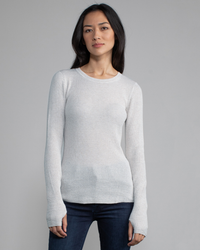 A woman wearing a Margaret O'Leary Shirttail Waffle Crew in Ivory/Salt standing against a gray background.