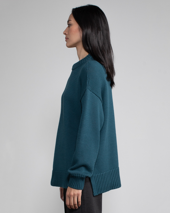 Side profile of a woman wearing a Margaret O'Leary Chelsea Pullover in Pine with a relaxed fit against a neutral background.