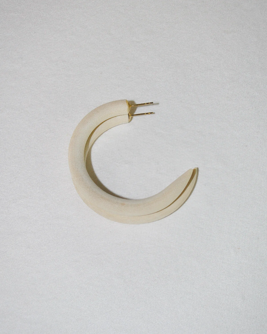 A B&L sustainably sourced mango wood c hoop in small with small metal prongs on a white surface.