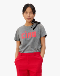 Woman wearing a Clare V. Block Ciao Classic Tee in Grey Melange with Neon Coral, paired with red trousers.