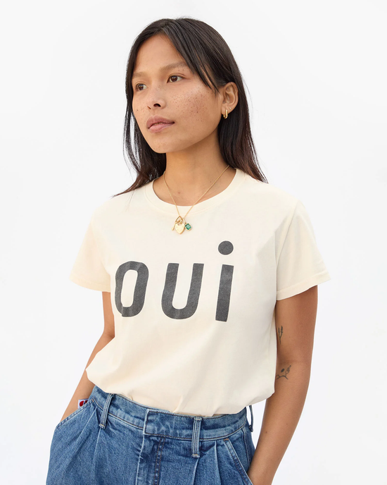 A woman wearing a Clare V. Oui Classic Tee in Cream w/ Black with the word "oui" printed on it.