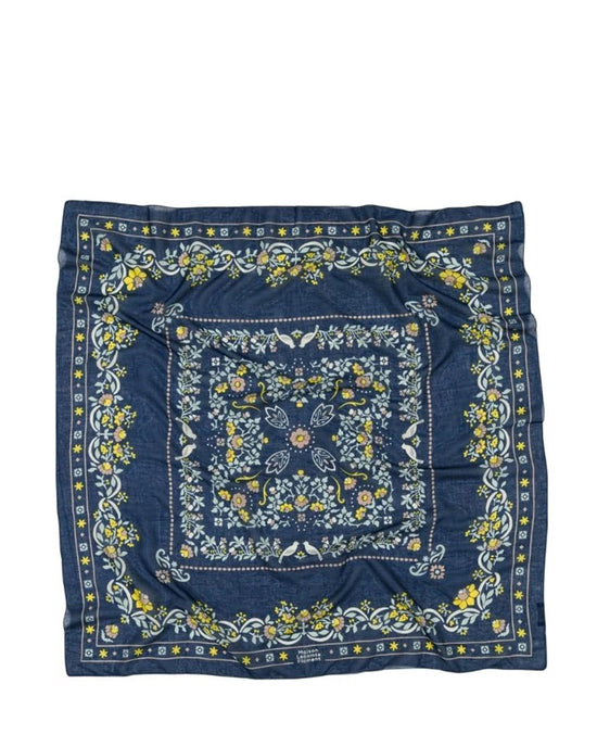 Maison Lecomte Flaments Secret Garden Cotton Bandana in Navy is a square cotton voile accessory with a blue background, floral pattern in yellow, green, and white, intricate borders, and a central motif.