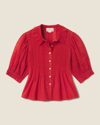 The Trovata Birds of Paradis Jess Blouse in Crimson Check, featuring a ruffled collar, button-down front, pintuck detailing, and gathered cuffs, is displayed on a neutral background.