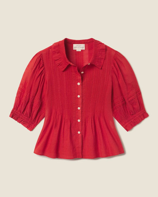 The Trovata Birds of Paradis Jess Blouse in Crimson Check, featuring a ruffled collar, button-down front, pintuck detailing, and gathered cuffs, is displayed on a neutral background.