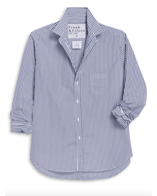 The Eileen Relaxed Button Up Shirt in White & Navy Stripe by Frank & Eileen is crafted from Italian cotton with long sleeves, a collar, one chest pocket, and partially rolled cuffs for effortless style.