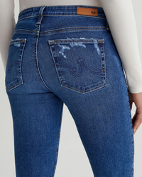 Close-up of a person wearing AG Jeans Prima in Brighton mid-rise jeans focusing on the back pocket detail.