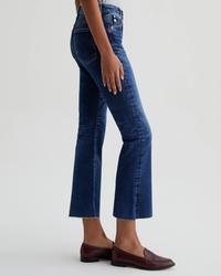 Woman wearing AG Jeans Farrah Boot Crop in 8Ys East Coast and loafers standing in a side profile view.