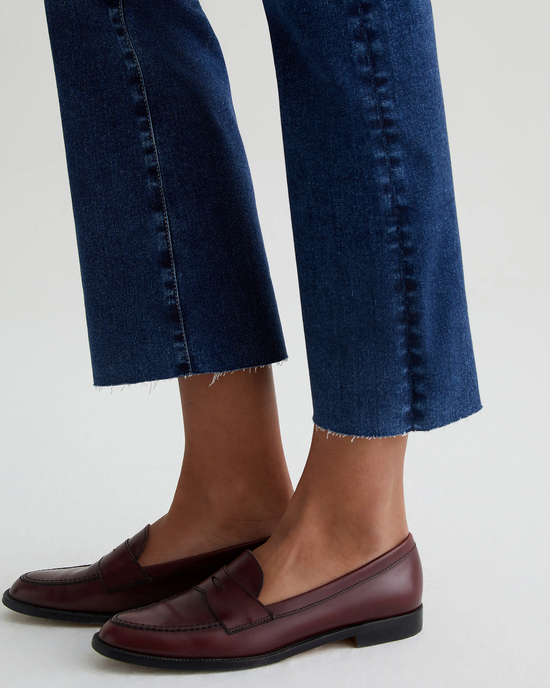 Close-up of a person wearing AG Jeans' Farrah Boot Crop in 8Ys East Coast and brown leather loafers.