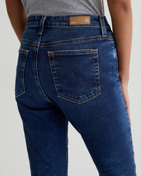 Close-up of a person wearing AG Jeans Farrah Boot Crop in 8Ys East Coast showcasing the back pocket and waistband design.