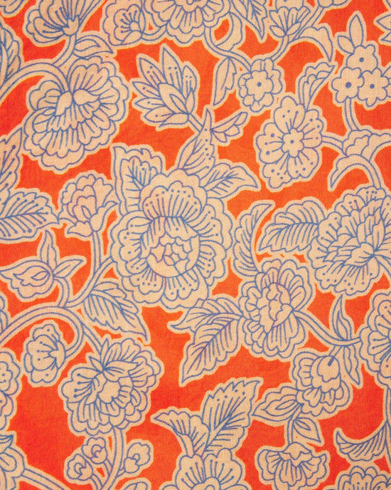 The Loren Blouse in Vermillion Vine by Trovata Birds of Paradis showcases an orange fabric with white and light blue floral patterns, ideal for a stylish puff sleeve look in 100% cotton.