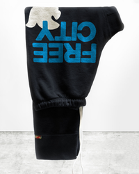 Large 3/4 Sweats in Blackspace Blue with "off-white" logo hanging upside down on a white wall, featuring screen printed "FREECITY" detail.