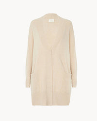 The Anja Open Cardi in Organic by Kujten is a long, cream-colored cashmere cardigan featuring an open front, two front pockets, and ribbed cuffs, hem, and edges.