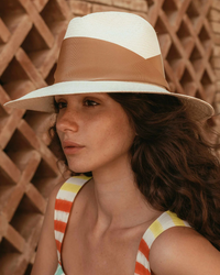 A woman wearing a Freya Gardenia in Natural/Tan tank top and a broad-brimmed fedora with a lattice background.