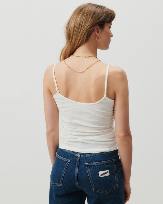 Woman from behind wearing a sleeveless Gamipy Tank in Blanc made of organic cotton by American Vintage and blue jeans.