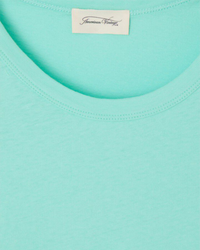 Close-up of a Gamipy Crop Tee in Lagon with an American Vintage clothing label, made from organic cotton.