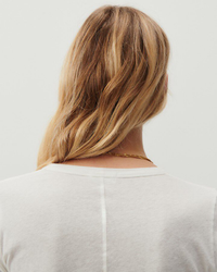 Woman with blonde hair wearing an American Vintage Gamipy L/S Top in Blanc viewed from behind.