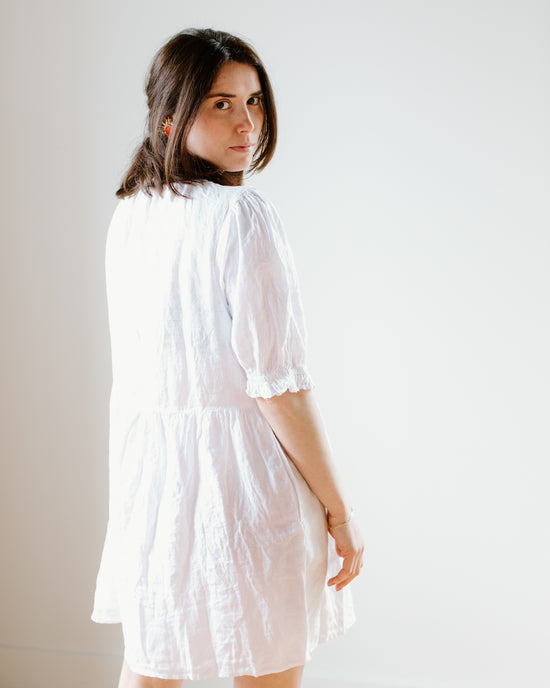 Woman in a Velvet by Graham & Spencer Kailani 3/4 Puff Slv Dress in White looking over her shoulder.