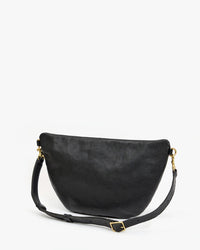 The Clare V. Grande Fanny - Petit Caviar in Black is a curved crossbody bag with an adjustable strap and gold hardware, showcased against a plain white background.