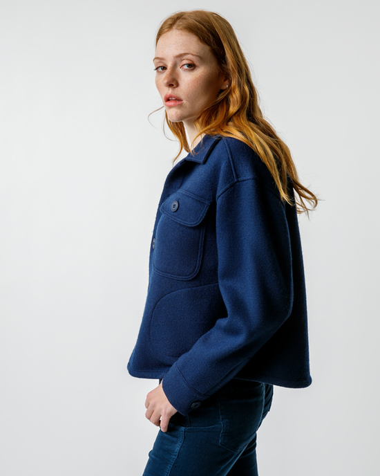 Woman in a AMO Halle Shirt Jacket in Neptune with an oversized silhouette turning her head to look at the camera.