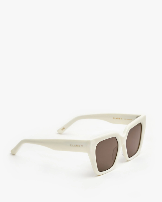 A pair of Clare V. Heather Sunglasses in Cream with UVA/UVB protection and brown lenses isolated on a white background.