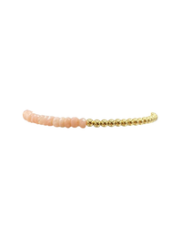 A 3MM Sig Bracelet with Pink Opal beads and Yellow Gold spheres on a white background by Karen Lazar Design.