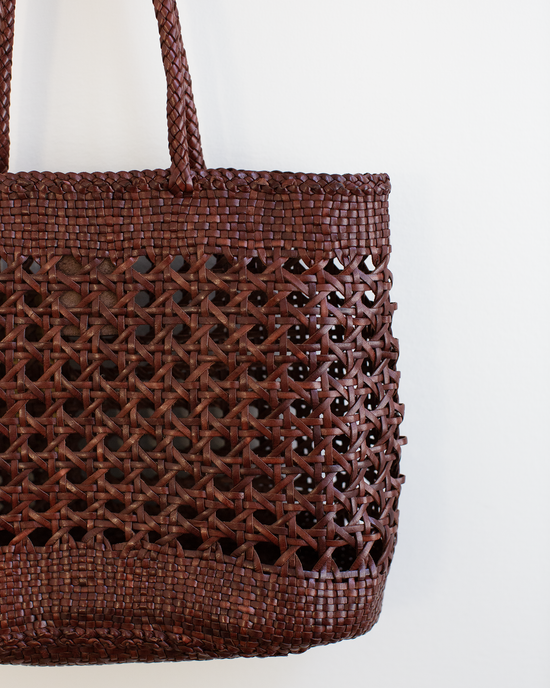 A close-up of the Dragon Diffusion Eclipse Bag in Bruciato, a handwoven brown tote with a detailed lattice pattern in supple buffalo leather, displayed against a plain white background.