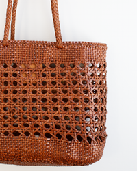 Close-up of the Dragon Diffusion Eclipse Bag in Tan, a buffalo leather basket-style tote featuring a lattice pattern and two handles, set against a plain white background.