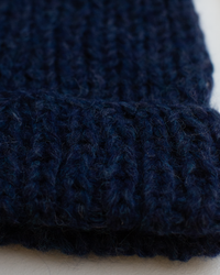 Close-up of the Chunky Alpaca Hat in Denim by Maiami, featuring thick, dark blue ribbed knit fabric with a folded edge.