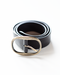 A rolled-up genuine leather Angus Leather Belt in Black with a metallic buckle on a white background by Hartford.