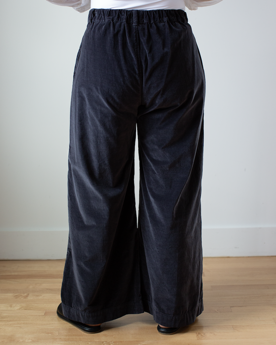 Person standing in Polly Wide Leg Pant - Cotton Velvet in Carbon by CP Shades against a white wall.