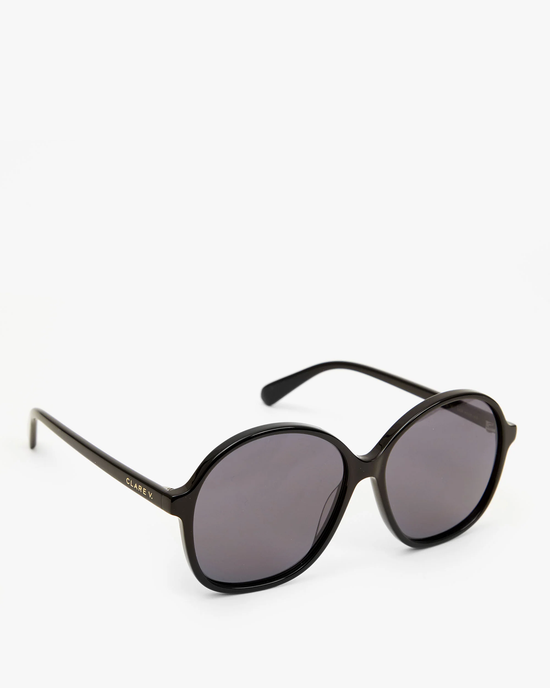 A pair of Clare V. Jane Sunglasses in Black featuring oval-shaped lenses with UV protection and thin black frames against a white background.