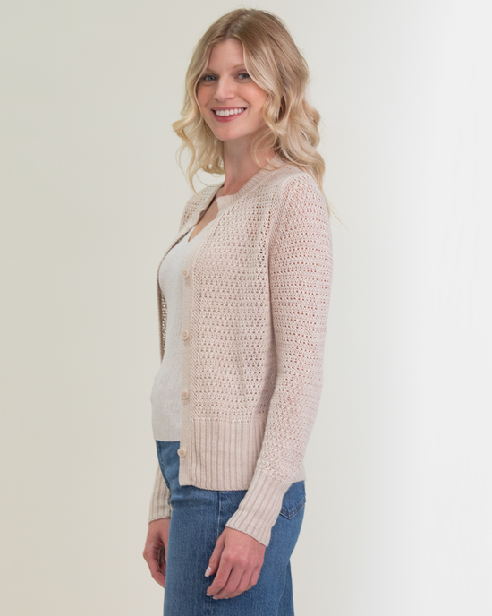Woman smiling in casual attire with a 100% Linen Margaret O'Leary Elodie Cardigan in Natural and blue jeans.
