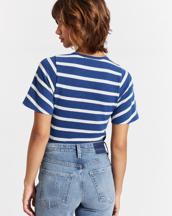 Woman wearing a nautical printed AMO Sylvie Tee in Natural/Navy and high rise denim seen from behind.