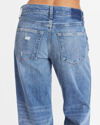 Close-up of the back of a pair of worn blue jeans with pockets showcasing a relaxed fit, like the AMO Billie Cropped Wide Straight in Warmth.