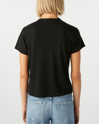 Woman viewed from behind wearing a black AMO Love Tee and blue jeans.