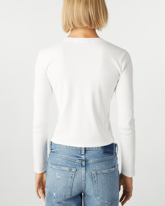 Woman wearing an AMO Slim Rib Tee in White and high-waisted jeans photographed from behind.