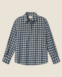 The Blake Oversized Shirt in Maritime Plaid by Trovata Birds of Paradis is a long-sleeve, oversized button-down with a blue, navy, and white plaid pattern, pointed collar, and chest pocket, shown laid flat on a light background.