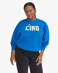 Woman in a Block Ciao Oversized Sweatshirt in Bright Cobalt w/ Cream by Clare V., paired with black pants, posing against a white background.