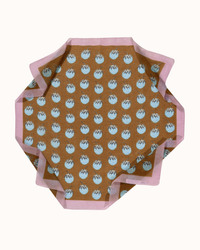 Hexagonal tabletop with a repeated acorn pattern on a brown background, surrounded by a pink border featuring the Épice Botanica Strawberries Bandana in Cannelle design.