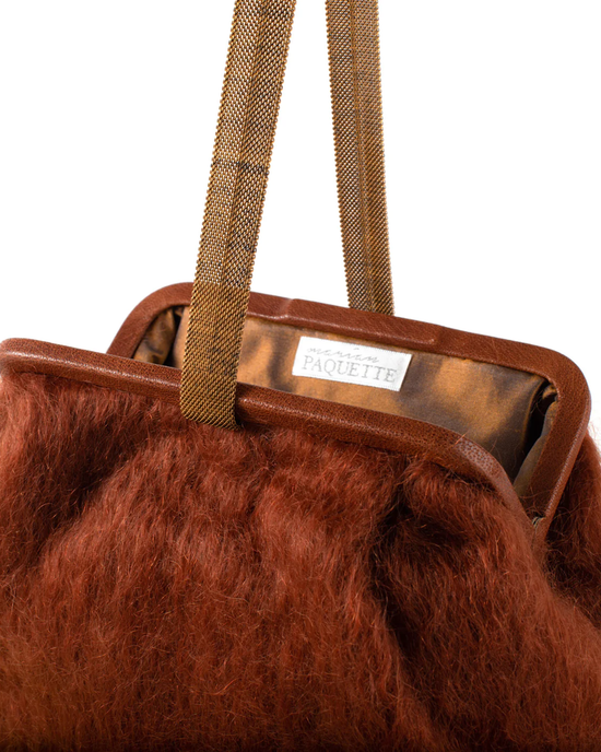 Close-up of a furry brown Susan Solid Mohair Clutch in Chestnut with a Vintage Chain Handle and a label reading "Marian Paquette".