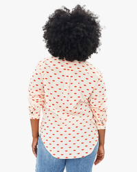 Woman from behind wearing a Clare V. Phoebe Blouse in Blush w/ Poppy Allover Lips and jeans.